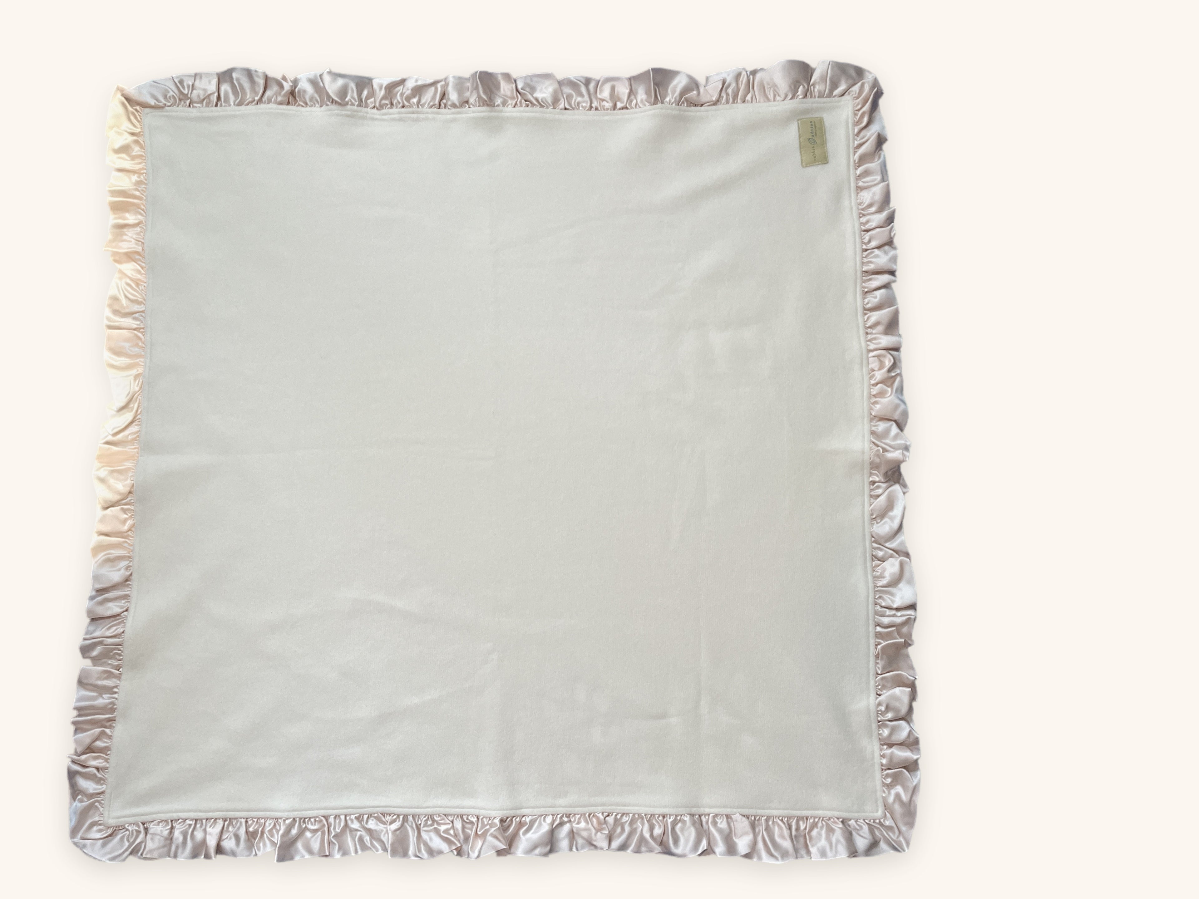 Organic cotton fleece baby blanket with blush pink silk charmeuse ruffle, shown flat