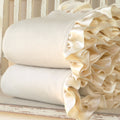 Cream organic cotton fleece baby blankets with silk charmeuse ruffle, folded and stacked